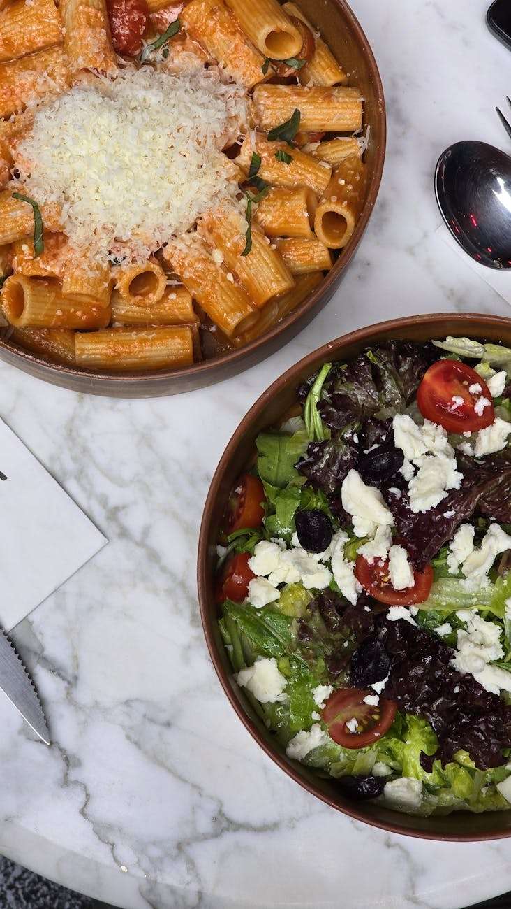 delicious pasta and salad on marble table